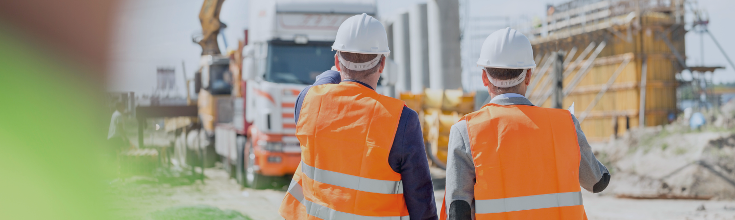 Two construction workers wearing high-vis vests at a construction site